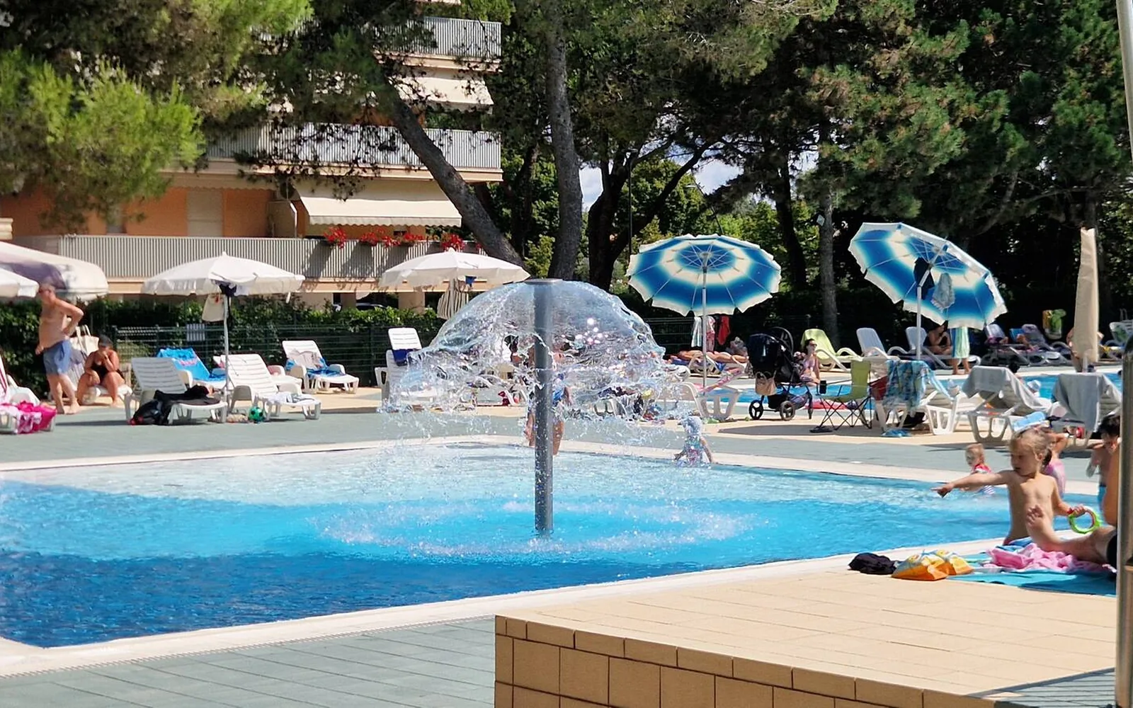 Piscina con giochi d'acqua e zona lettini — Casa Vacanze Monachy Beach, Bibione